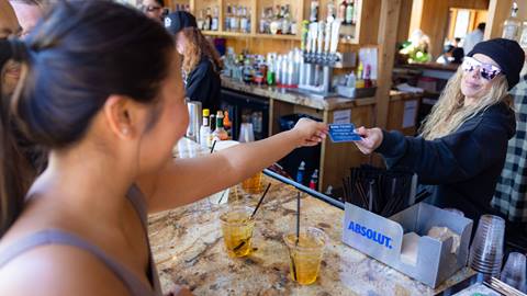 Drink ticket voucher exchange from adult to bar tender.